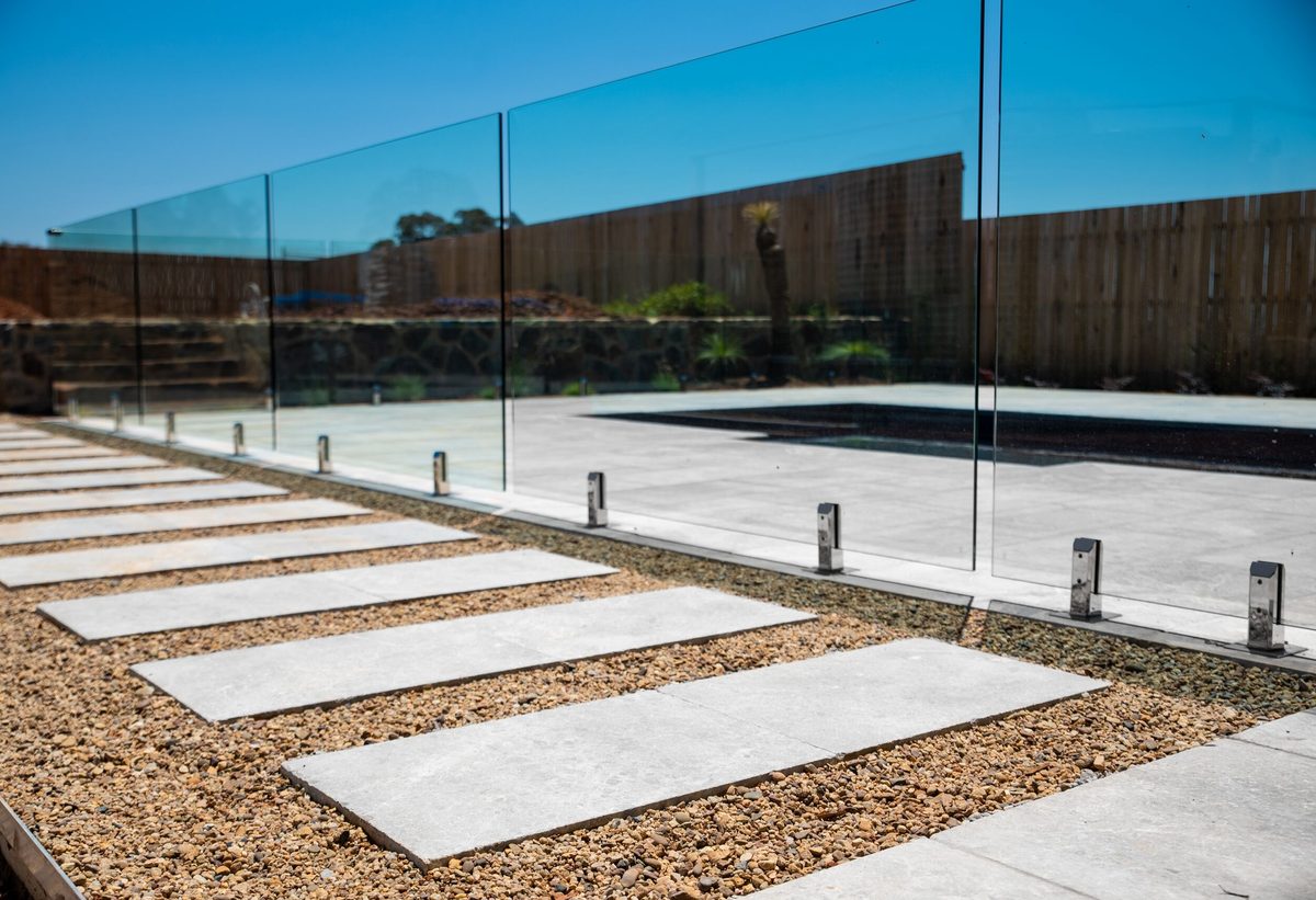Pool deck with glass balustrade and stepping pavers