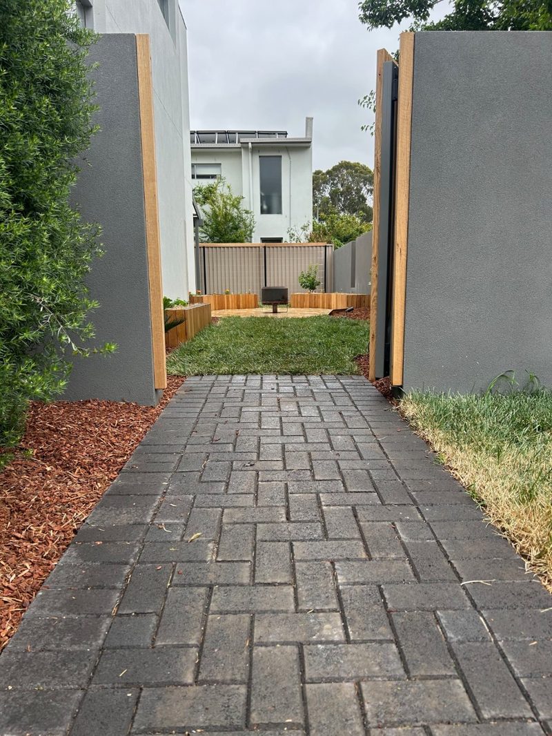 Paved walkway between rendered walls