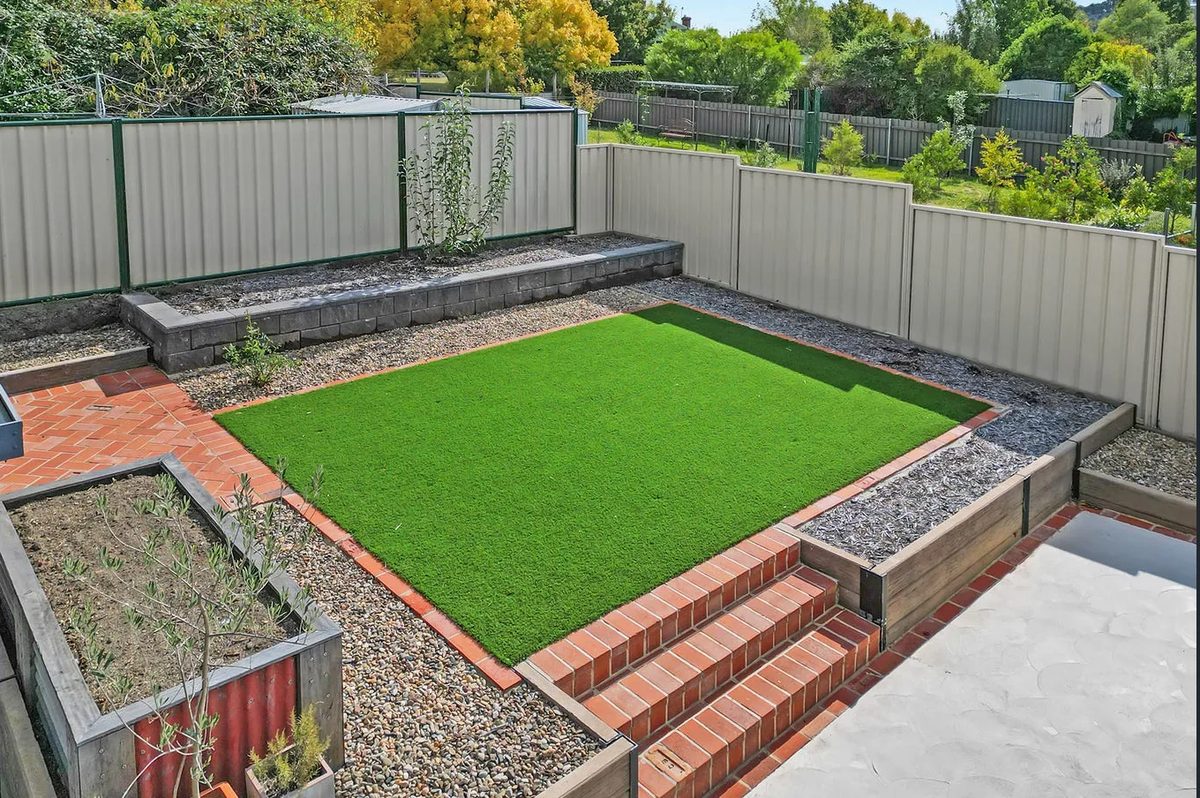 Turf lawn with brick edging, steps and raised garden beds